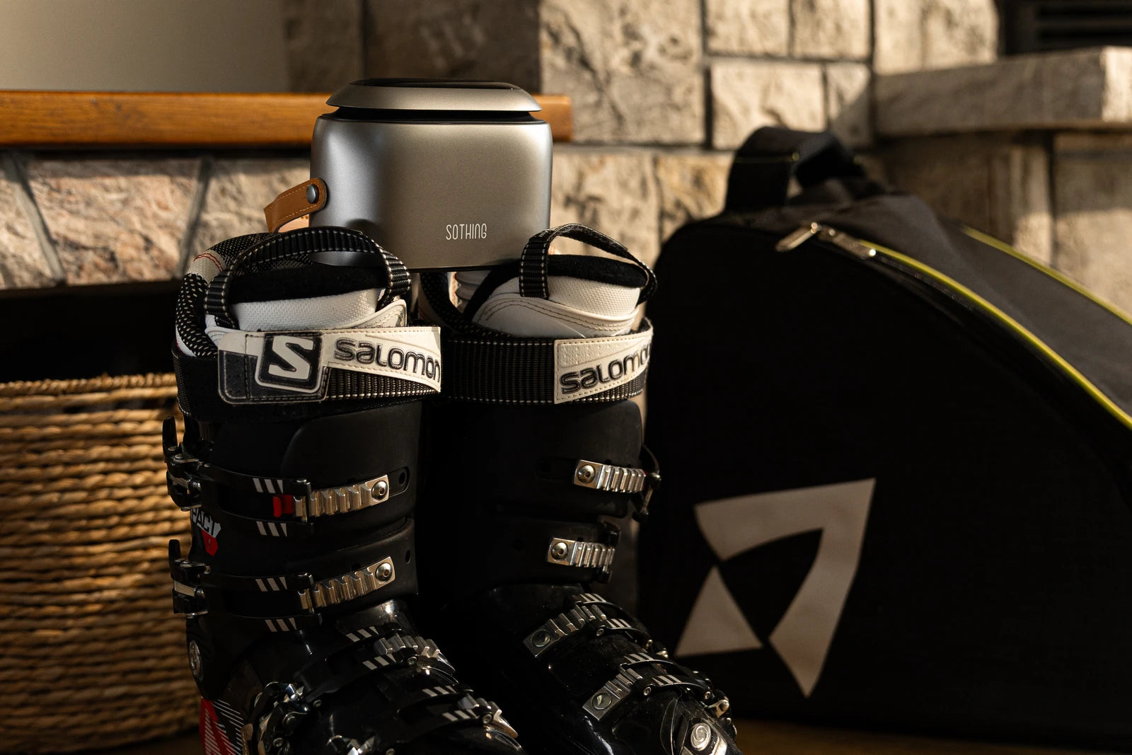Photo originale SOTHING Ultra Grey avec bottes de ski Salomon noires près d'un mur de pierre